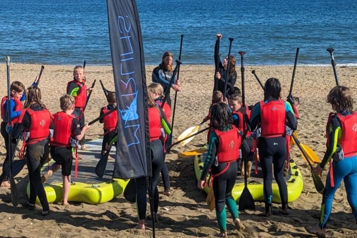a group of people on a beach near a body of water